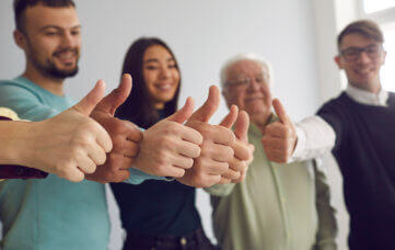 group of people doing thumbs up